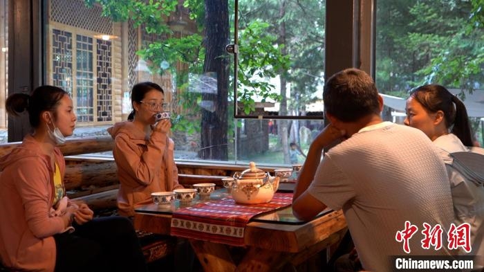 羊茸村妇女在做民宿管家，正与游客交流。　唐启浩 摄